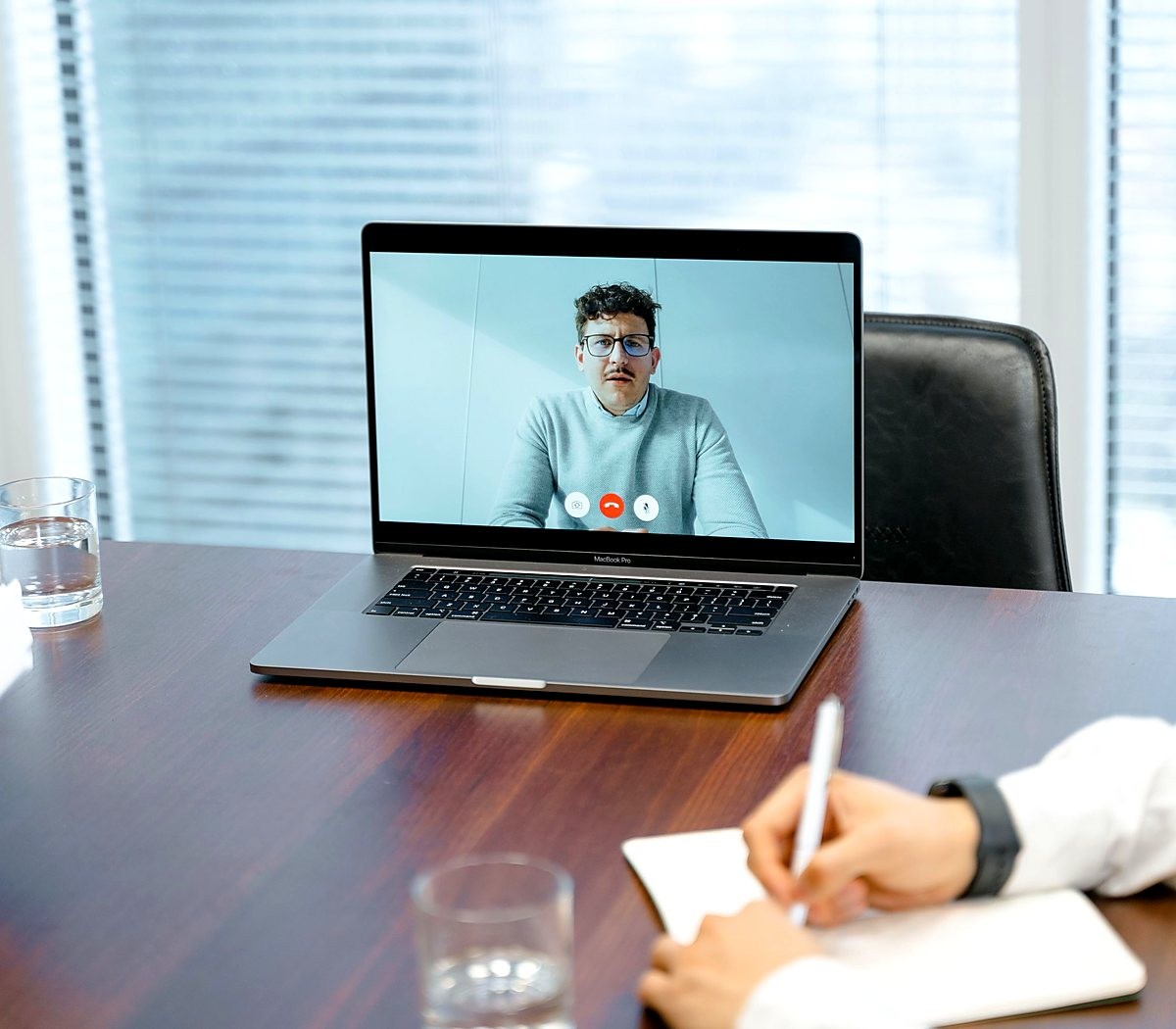 Videochamada no notebook com anotações à mão sobre a mesa
