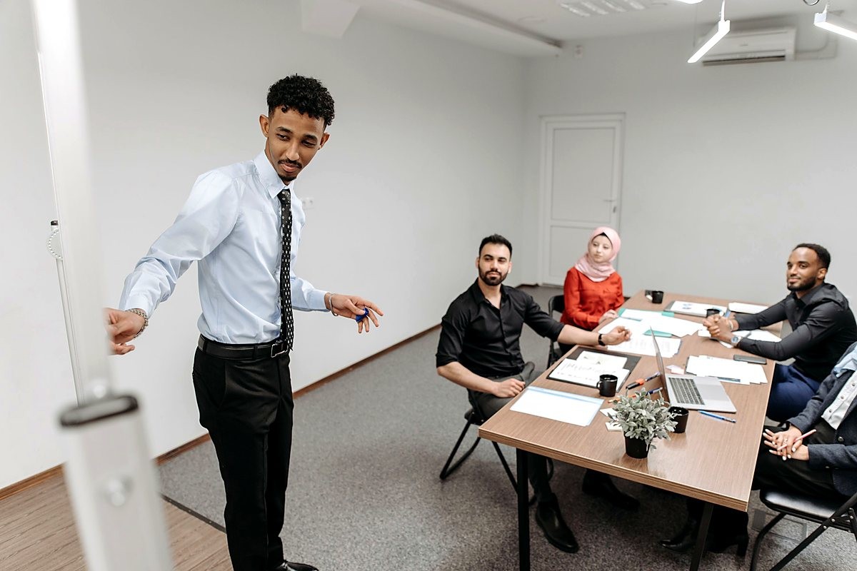 Profissional apresentando em uma sala de reunião com a equipe
